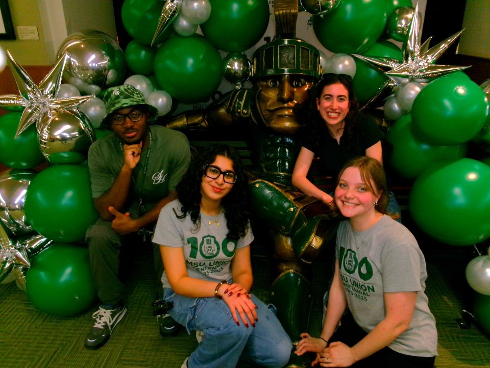 Students posing in front of Bronze Sparty and balloons for Centennial Celebration Finale
