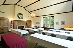 A view of another MSU Union meeting space that has rows of tables with white tablecloths and chairs, and windows to the right.