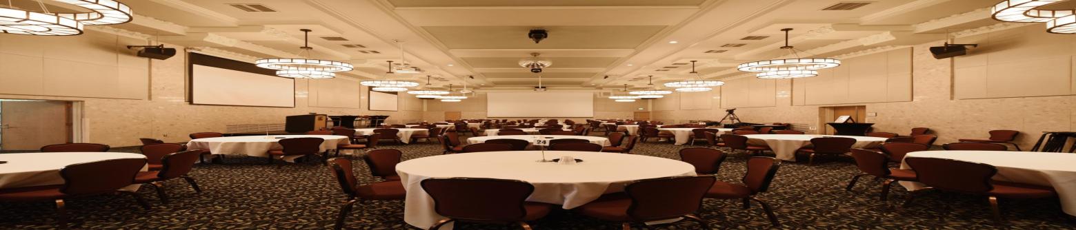 MSU Union Ballroom photo featuring table rounds of eight, chairs, disco ball, and chandeliers